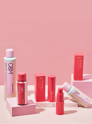 Collection of O&M skincare products on a pink background